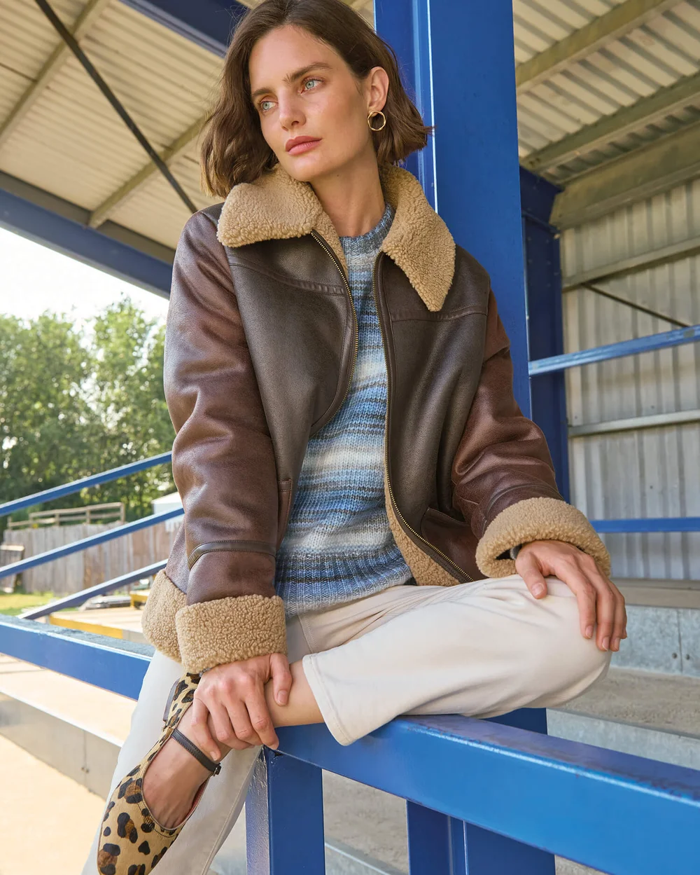 Femme en brown jacket with bleu striped sweater et leopard print shoes