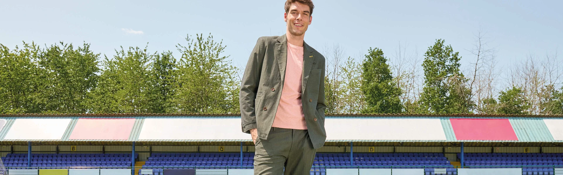 Homme portant une veste et un pantalon verts assortis avec un haut rose