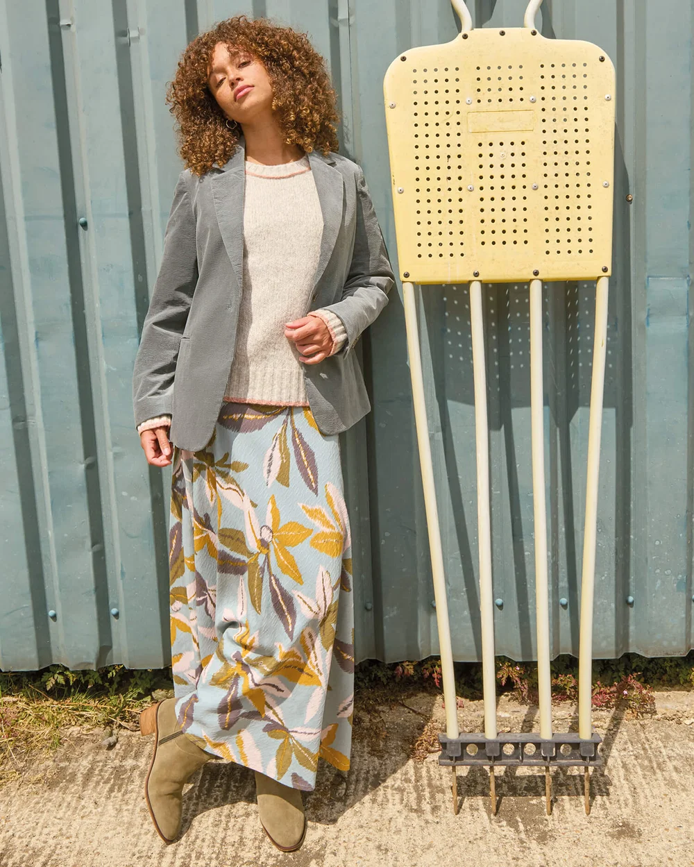 Sur la photo à droite, elle porte la tenue avec un blazer vert.